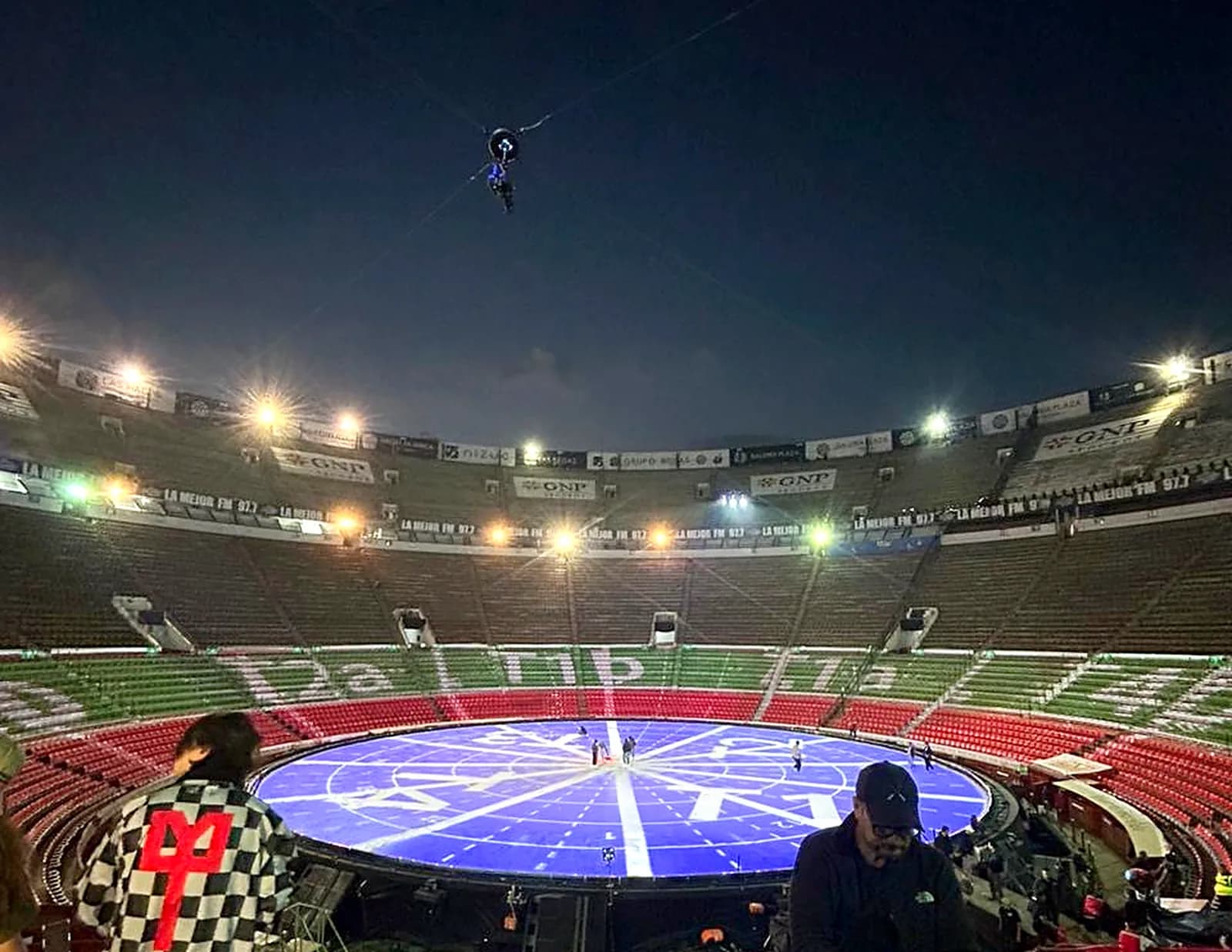 Plaza de Toros de la Ciudad de México de noche durante el montaje de la gira de Kanye West, con escenario circular iluminado
