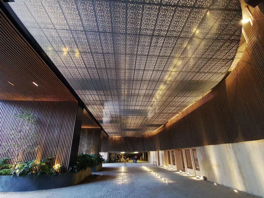 Acceso y lobby de Original Pedregal, residencial de Sordo Madaleno, con plafón metálico perforado y audio distribuido integrado