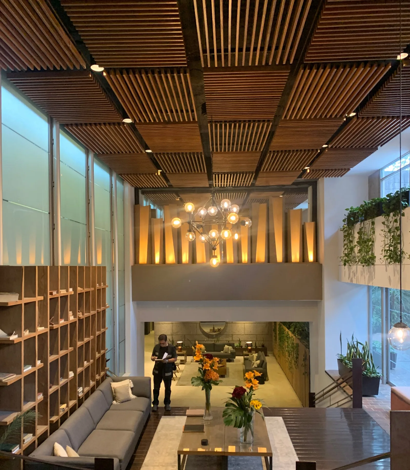 Lobby de doble altura del Residencial Tamarindos en Santa Fe con plafón de duelas de madera y audio distribuido oculto